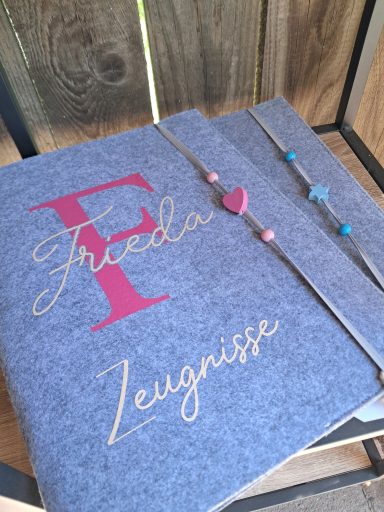 Graues Notizbuch mit goldener Schrift und Herzen, personalisiert mit dem Namen "Frieda".