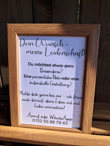 Ein gerahmtes Plakat mit der Schrift: "Dein Wunsch – meine Leidenschaft" und Kontaktdaten.
