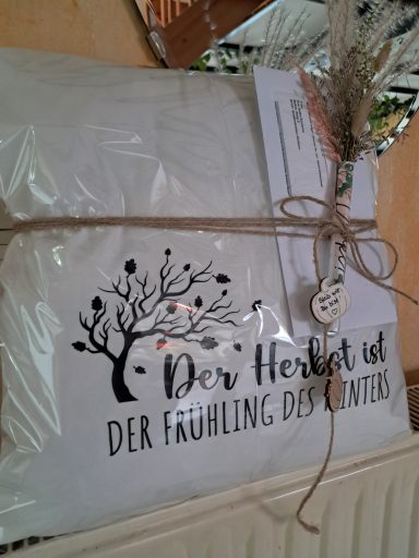Geschenkverpackung mit dem Schriftzug "Der Herbst ist der Frühling des Winters" und Dekoration.
