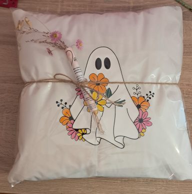 Kissen mit einem freundlichen Geist und bunten Blumenmotiven.