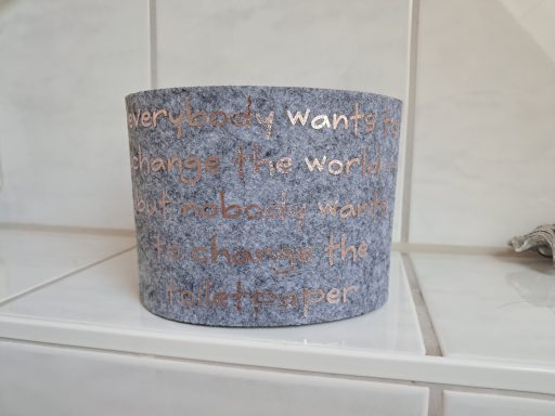 Grau-weißer Behälter mit goldener Aufschrift über die Veränderung der Welt.