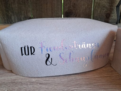 Helle, bedruckte Stoffoberfläche mit dem Schriftzug "Für Friseure & Schönheitsfans".