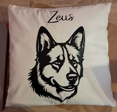 Kissen mit schwarzem Hundemotiv und dem Namen "Zeus" oben.