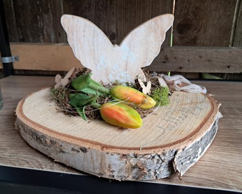Dekorative Holzplatte mit Schmetterlingsmotiv und bunten Früchten.